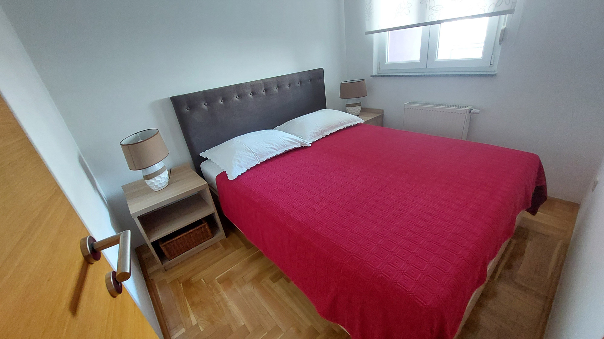 Bedroom with red bedspread and lamps