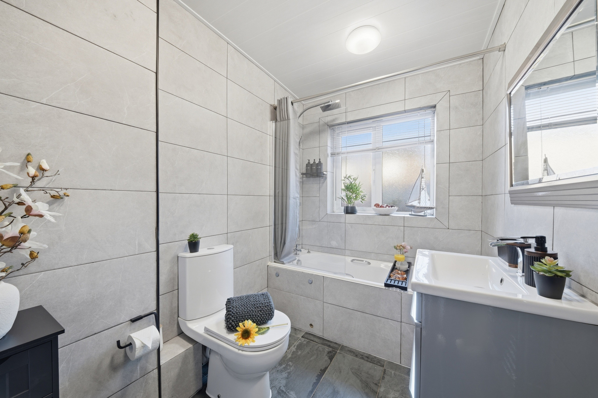 Grey tiled bathroom with bathtub