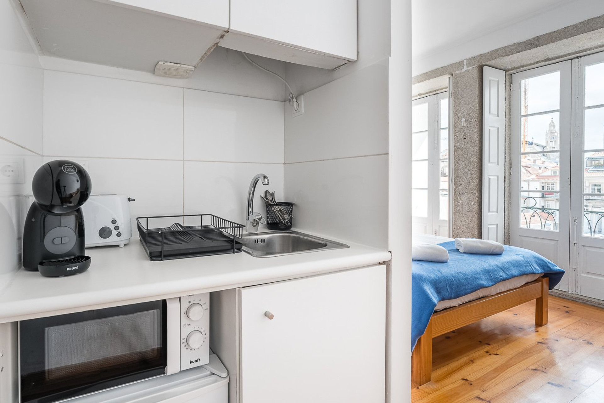 Kitchen area with bed beyond