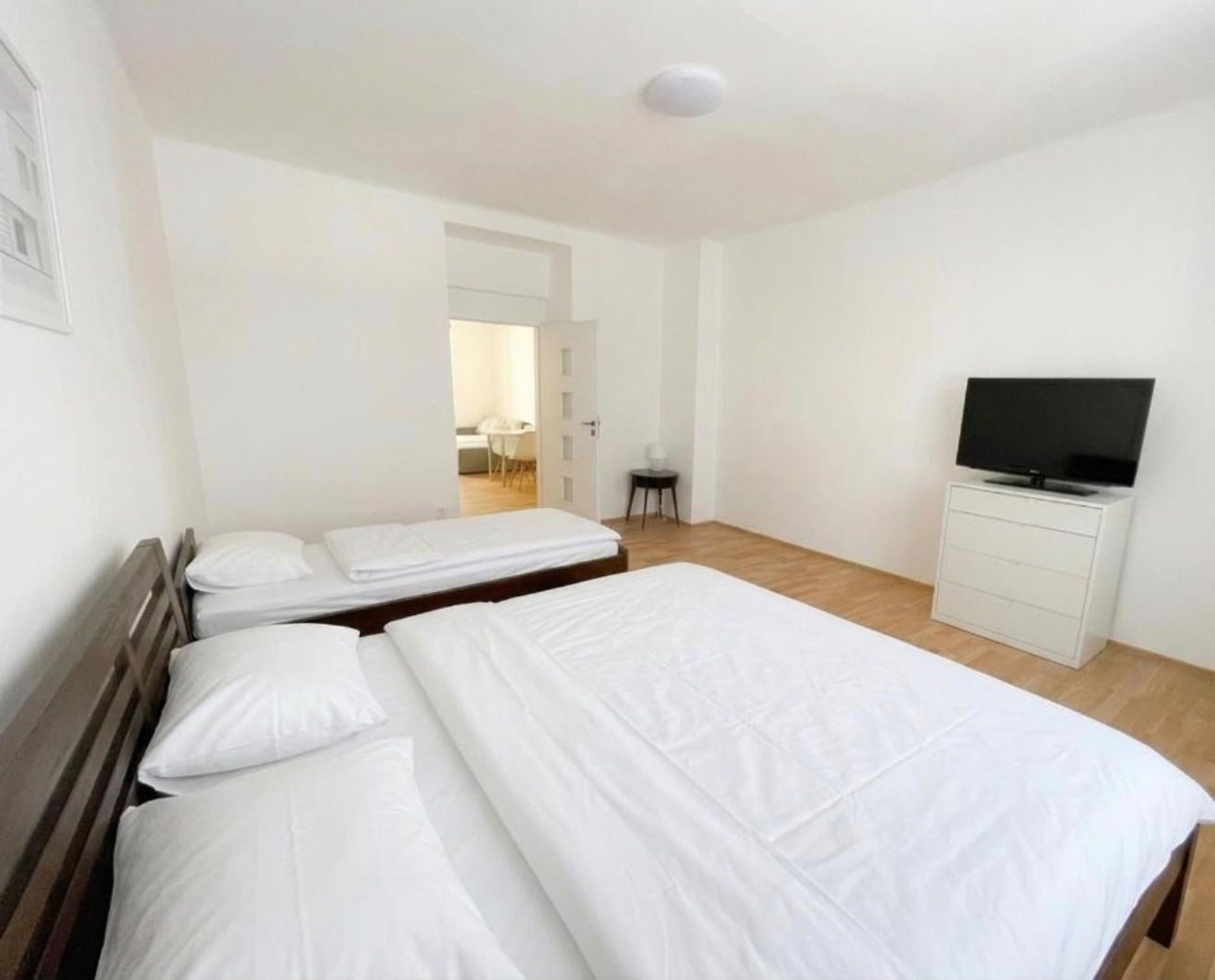 Bright bedroom with beds and TV