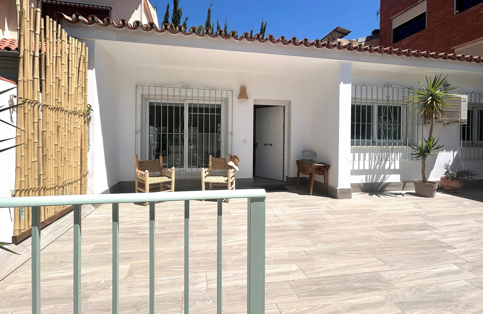 Vista de la puerta de entrada desde la calle. Se puede ver parte del patio delantero. 