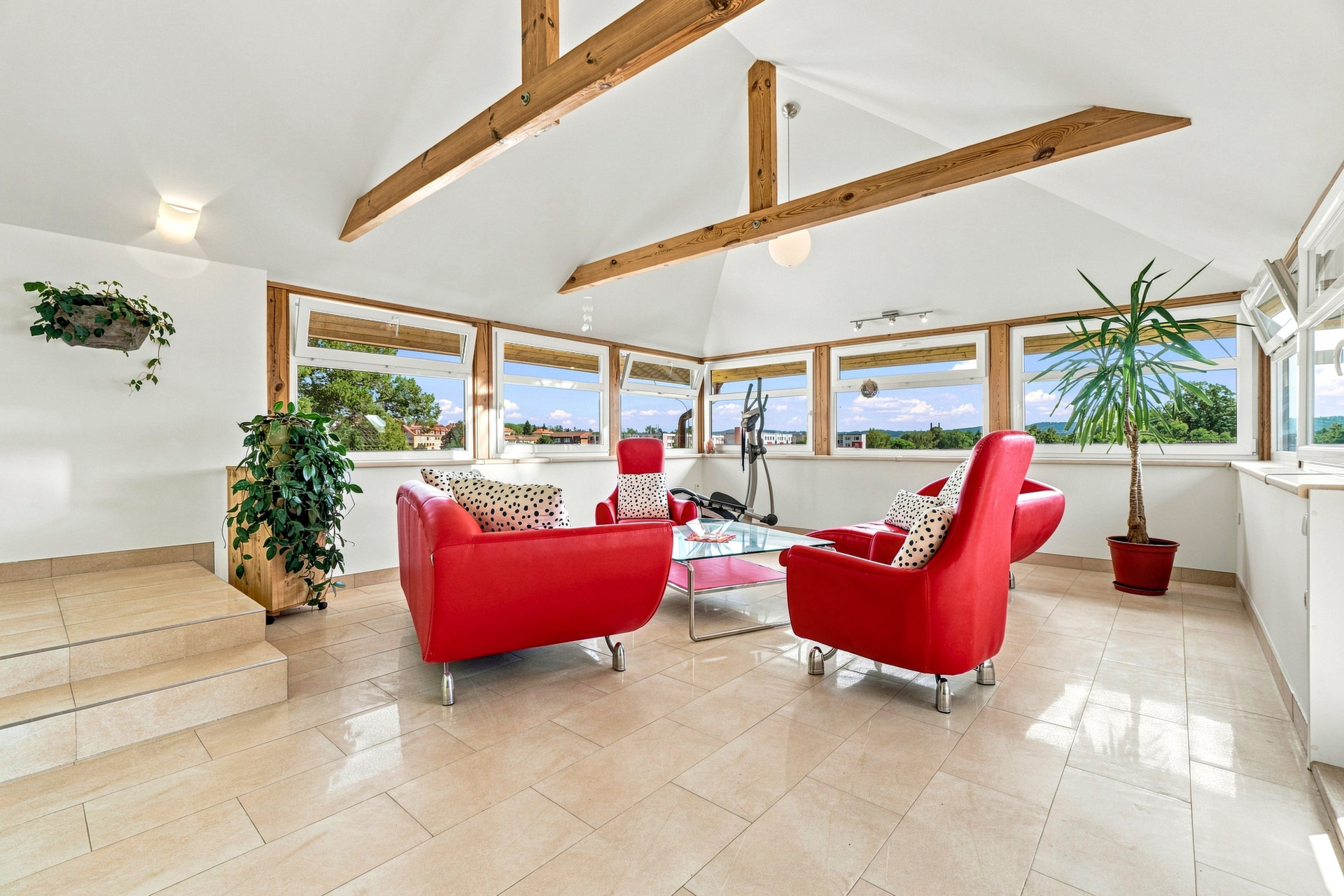 Bright sunroom with red armchairs