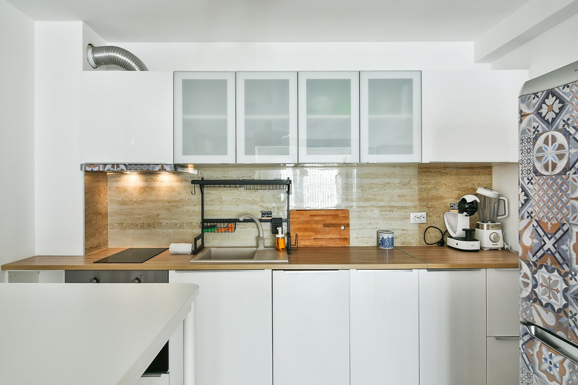 Modern fully equipped kitchen – A sleek and stylish kitchen featuring white cabinetry, warm backsplash tiles, and under-cabinet lighting. Complete with all essential appliances, making it perfect for preparing meals with ease.