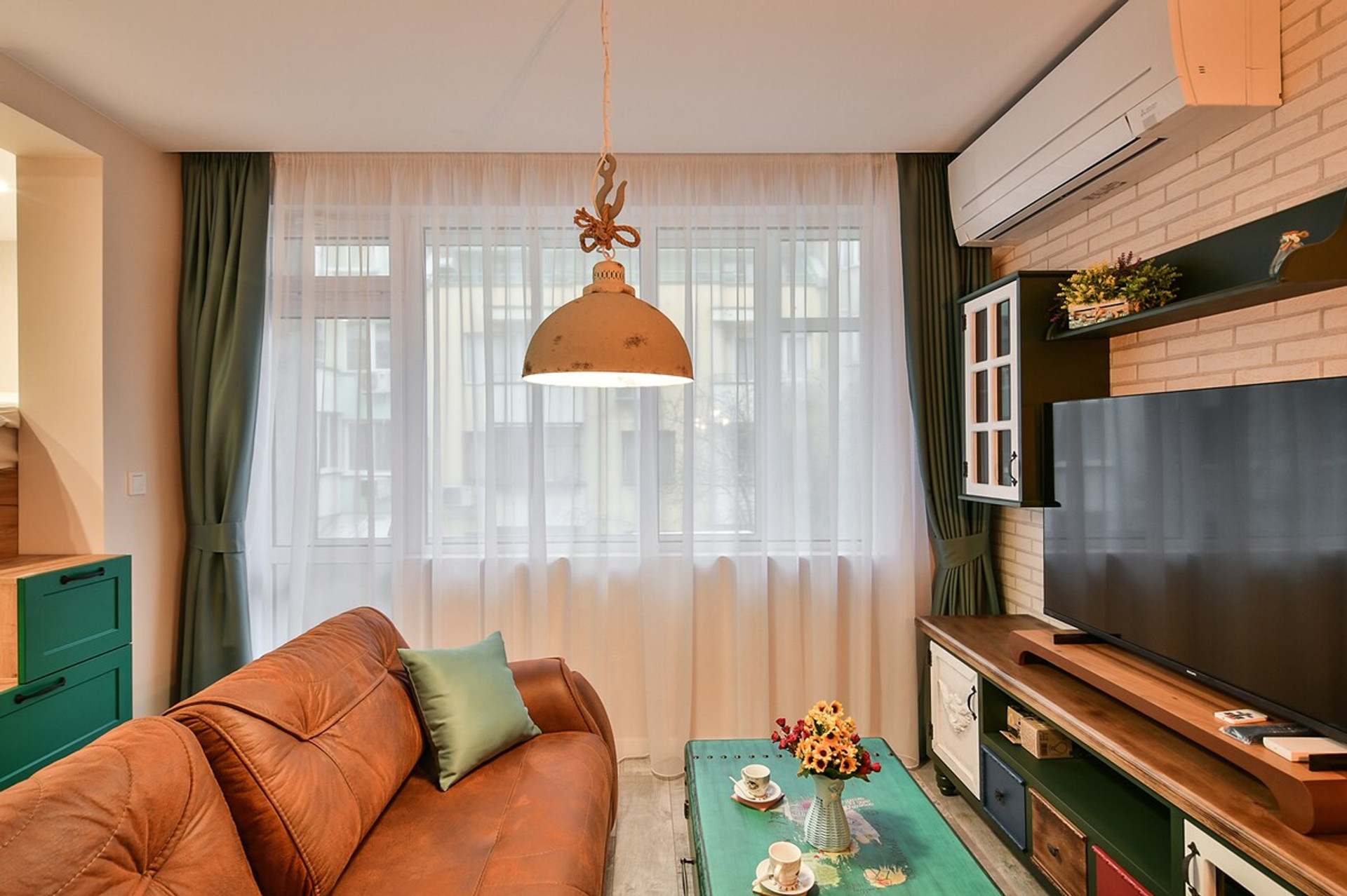 Elegant TV lounge with warm lighting – A cozy entertainment area with a large flat-screen TV, wood and brick elements, and stylish decor that blends modern and rustic aesthetics.