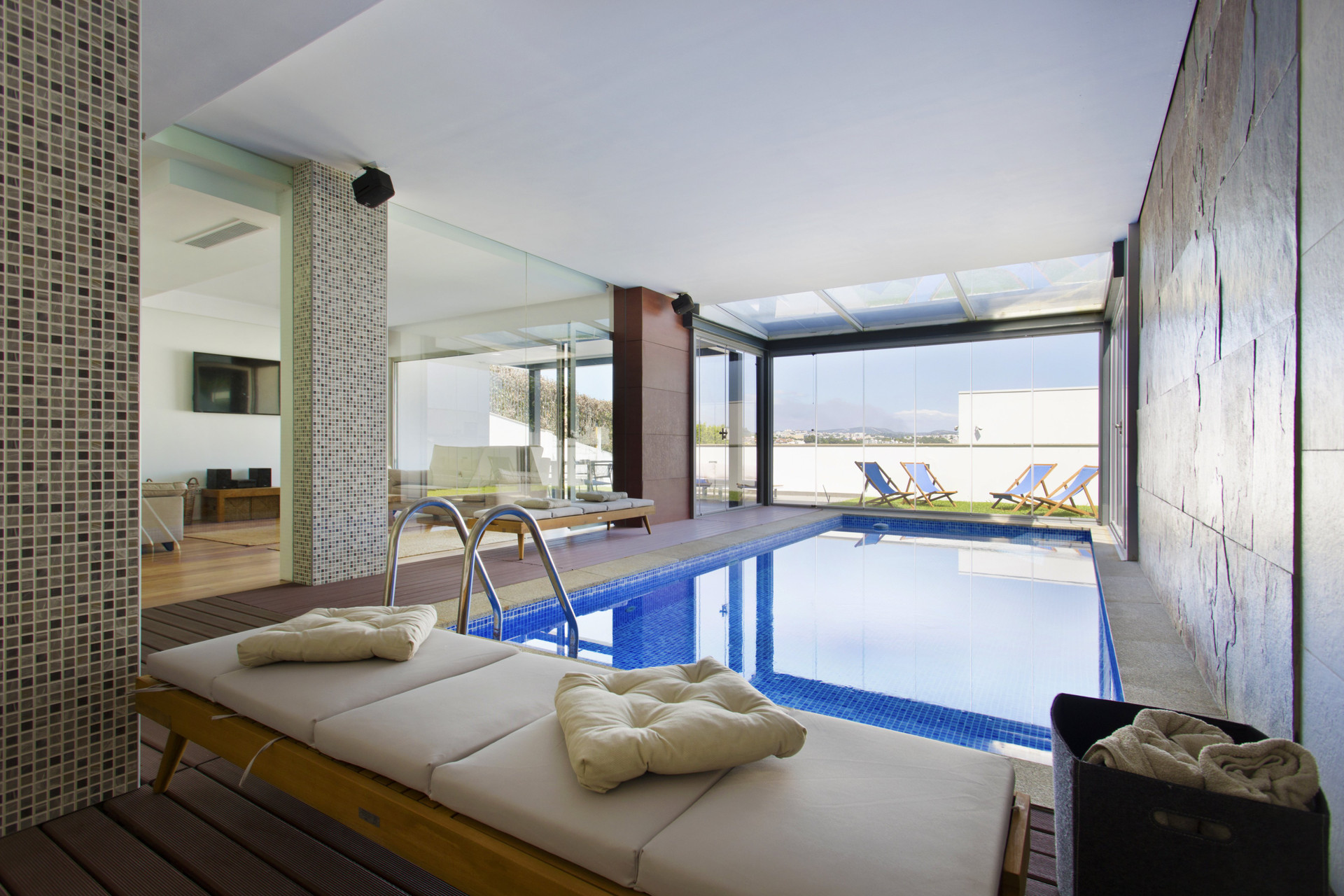 Indoor pool with sunbeds and terrace