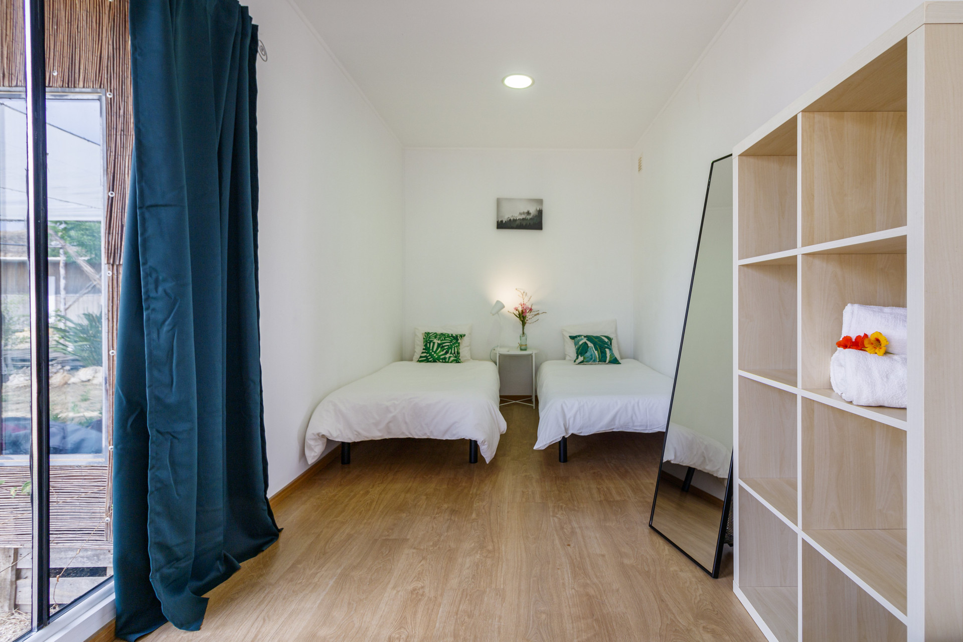 Twin bedroom with teal curtains