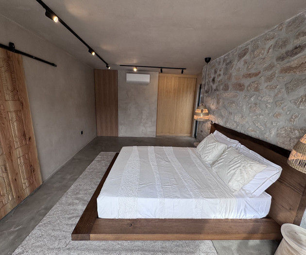 Bedroom with stone wall, wardrobes