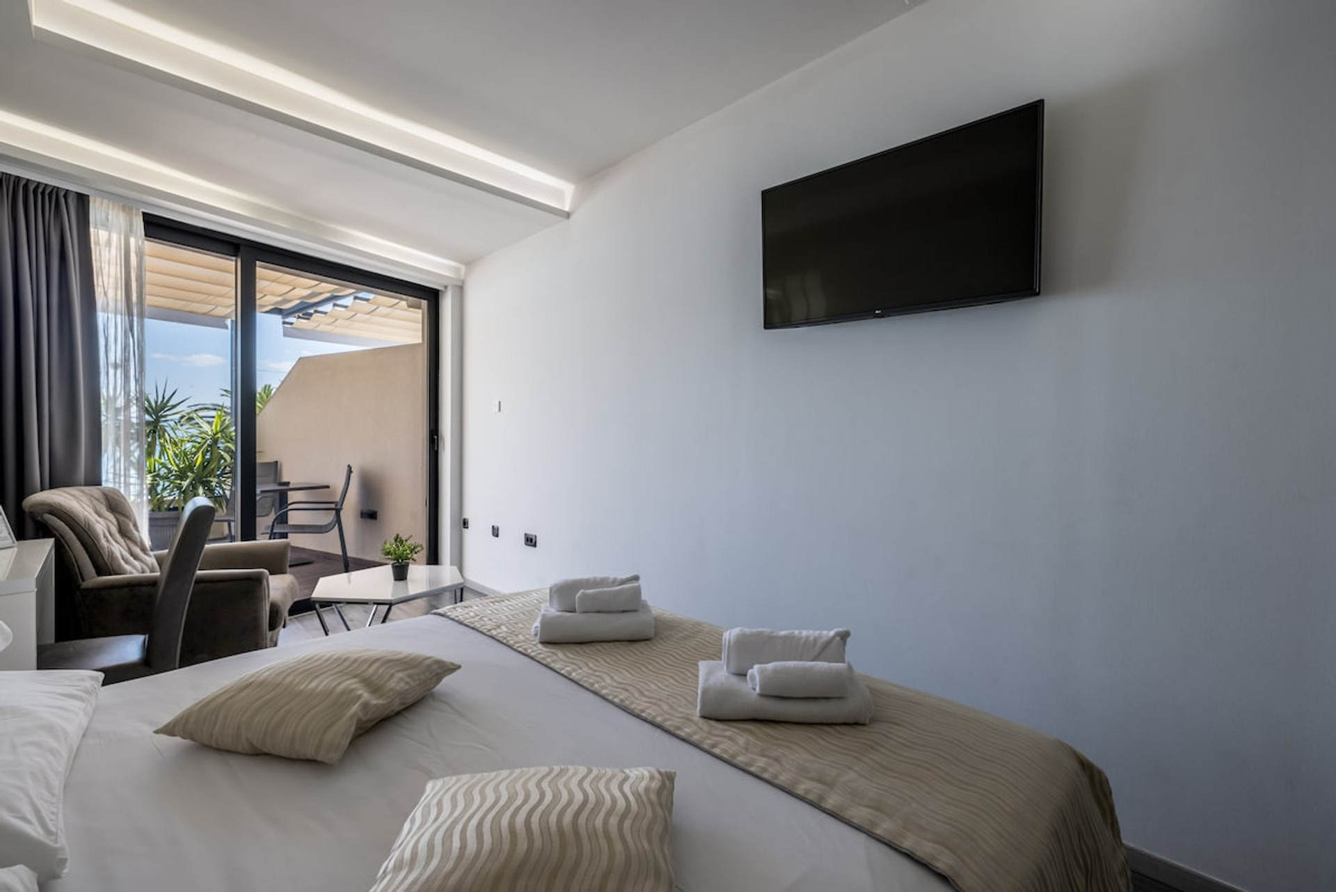 A comfortable bed facing a flat-screen TV.