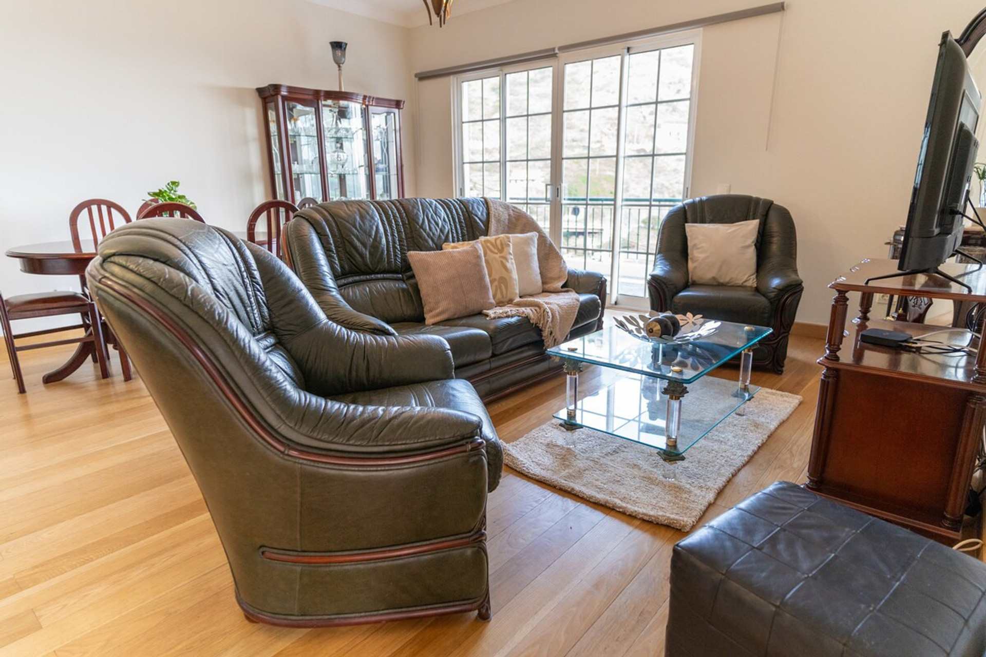 Large living room, with large windows and sea view. Contemporary furnishings, wooden floors and natural lighting create a relaxing and elegant atmosphere.