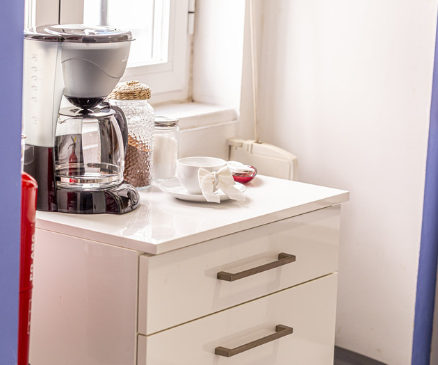 Coffee maker on white cabinet
