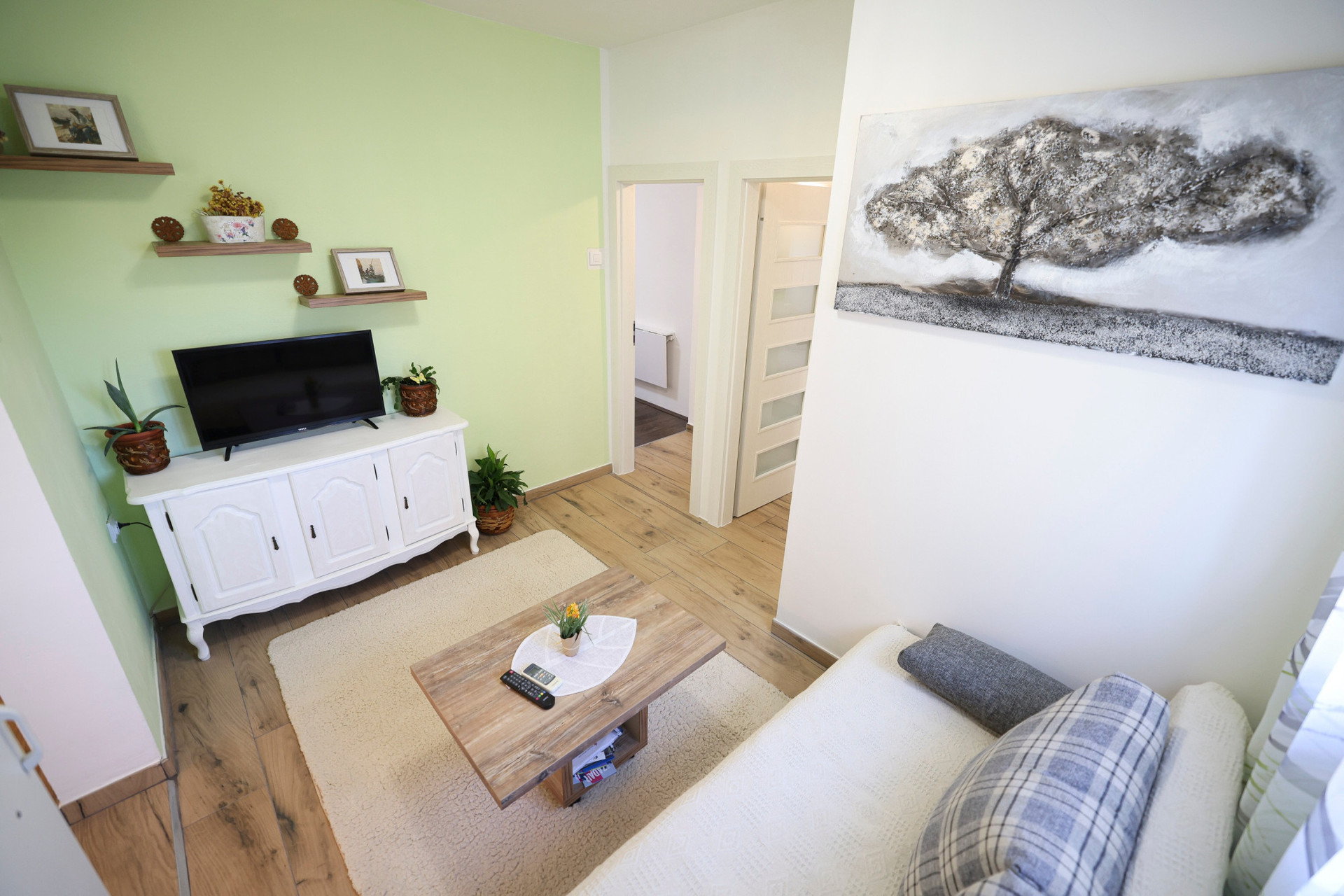 a cosy living room with couch,cabel tv