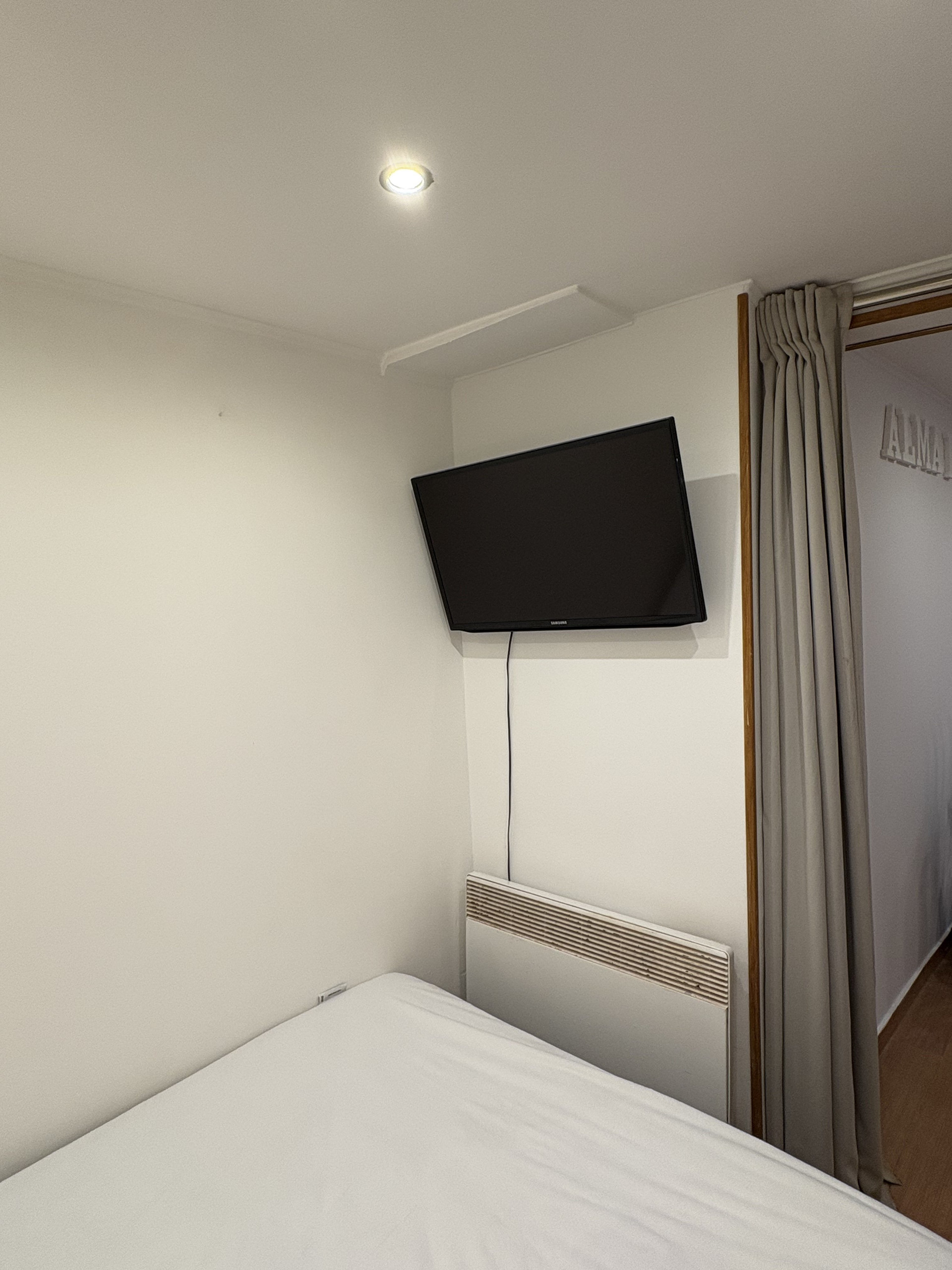 Bedroom with wall-mounted TV