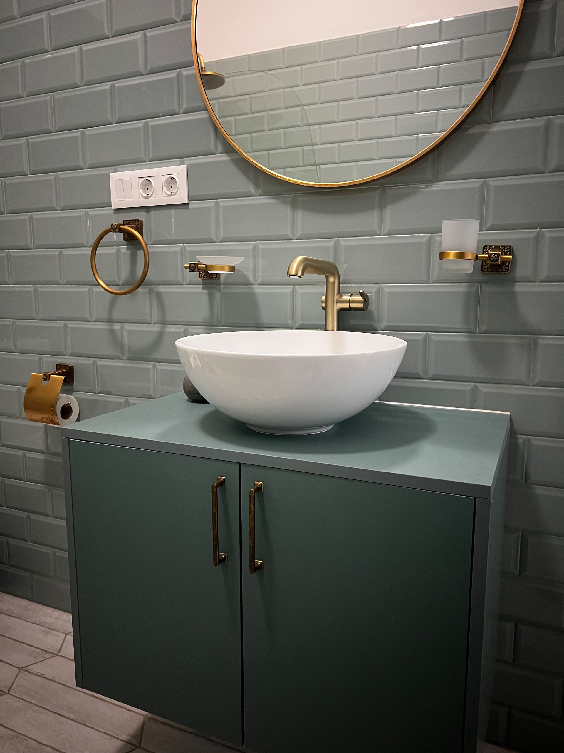 Features a large vanity mirror with gold accents and a stylish tiled design.