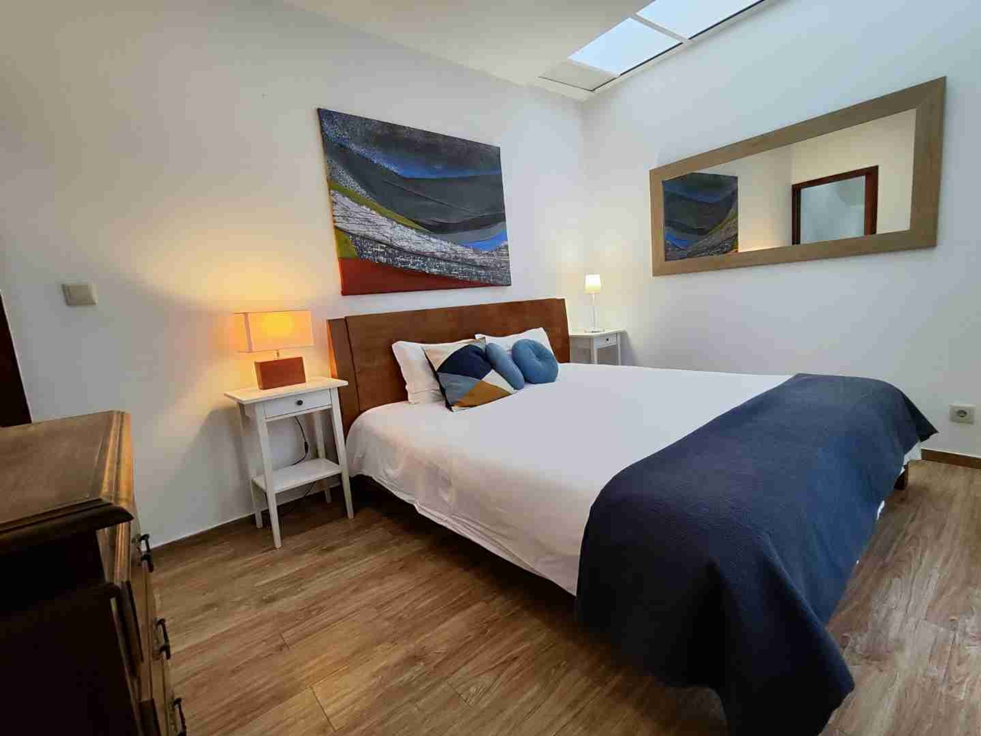 Bedroom with skylight and mirror