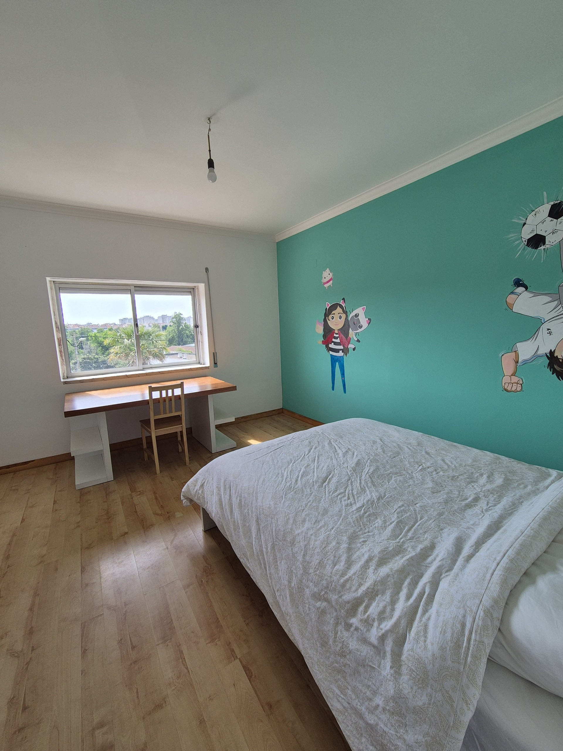 Bedroom with colorful anime wall. Dedicated workspace.