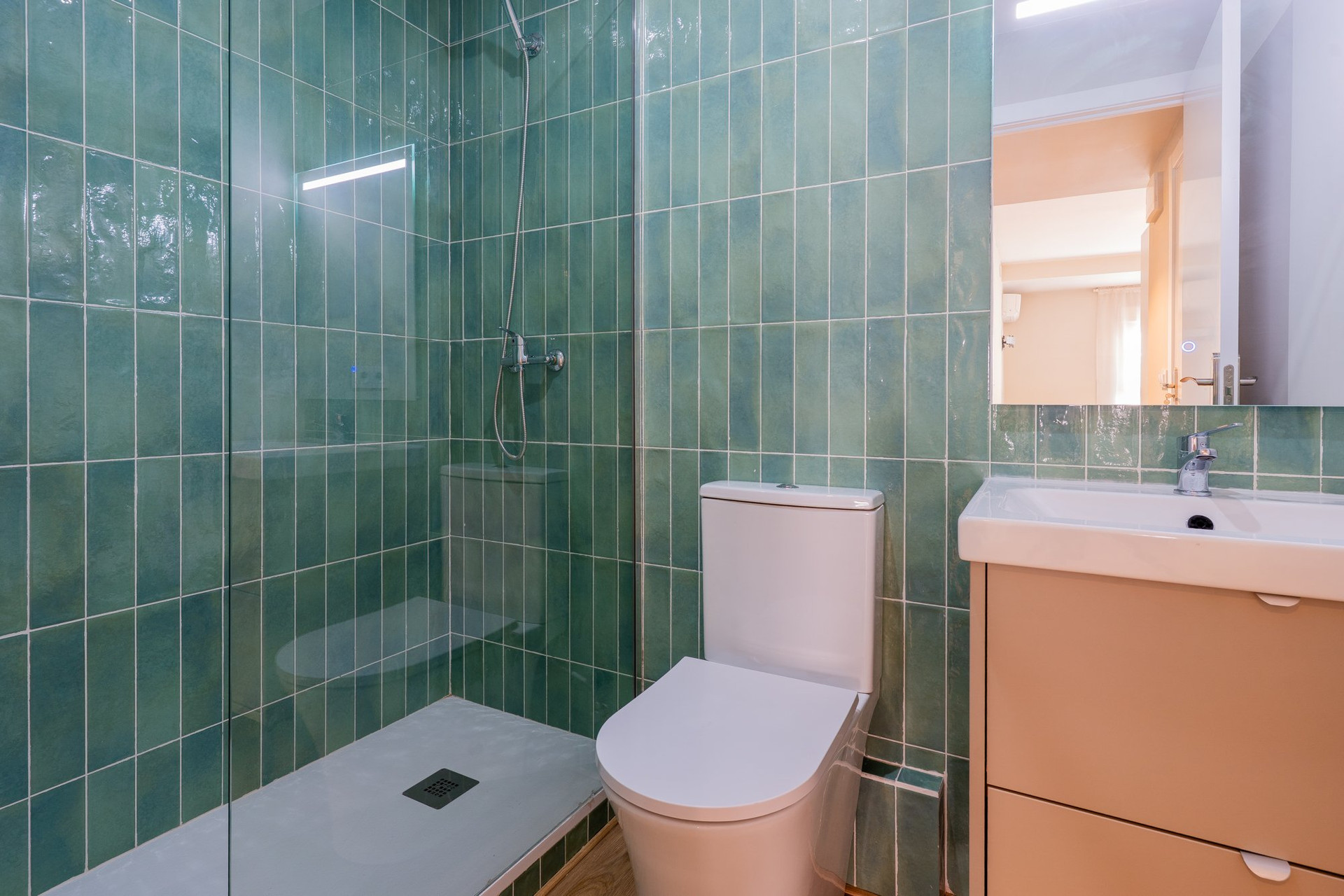 Green tiled bathroom with shower