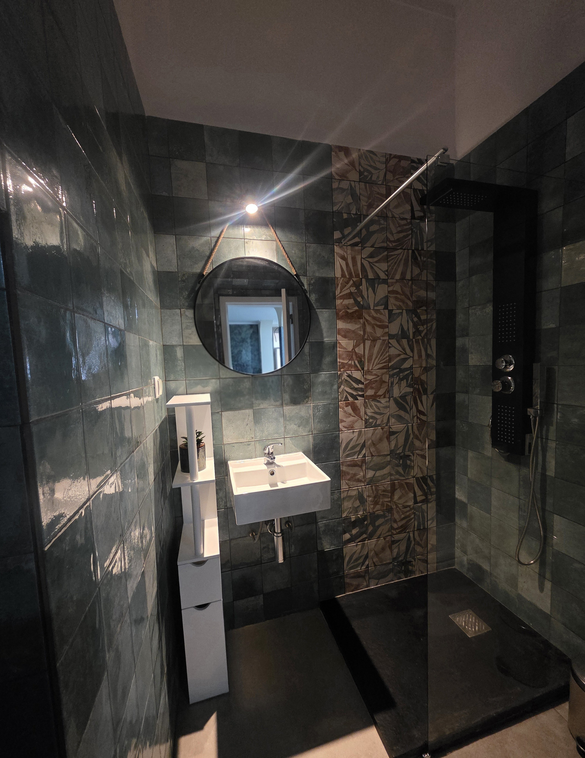 Dark tiled bathroom with walk-in shower