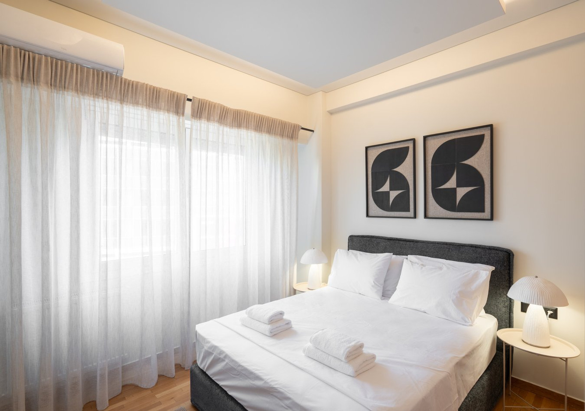 Bedroom with balcony curtains and art