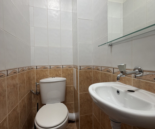 Compact toilet with wall tiles