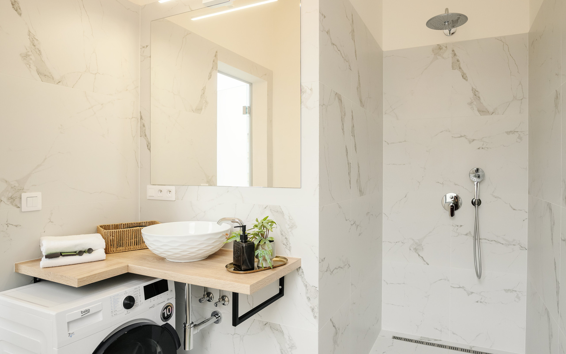 Marble bathroom with shower and washer