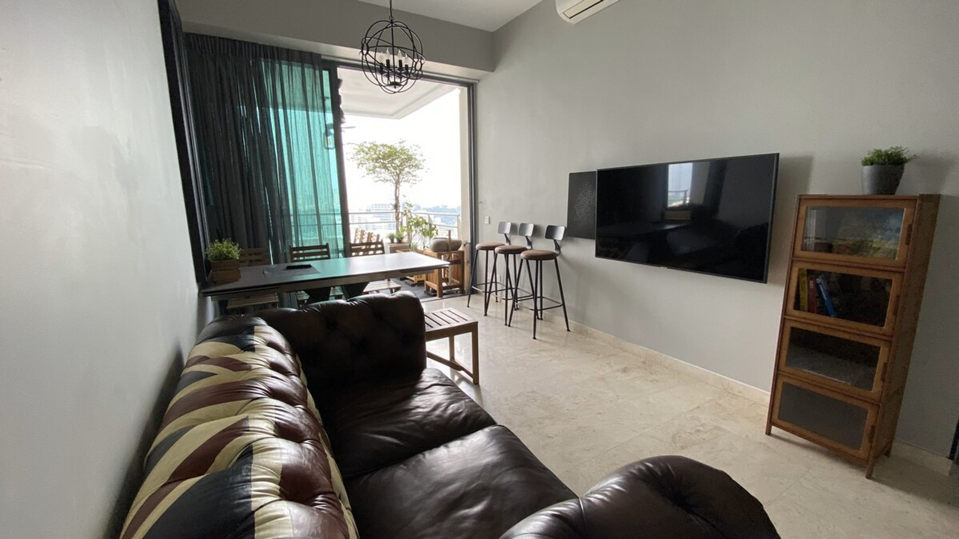 Living area with top grain leather sofa, Sonos wall blue tooth speaker, 4k smart TV, mini library and indoor and outdoor dining.