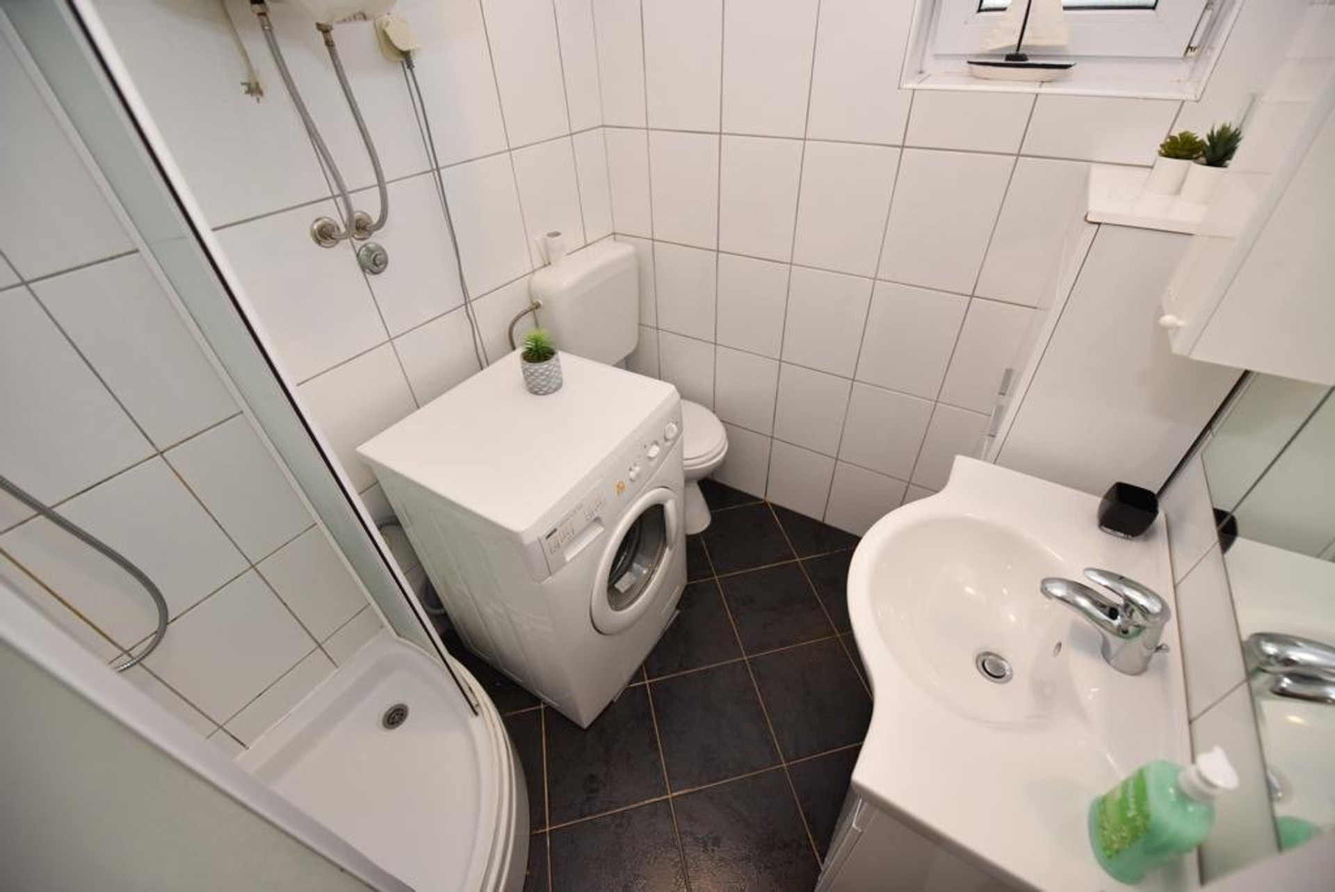 Bathroom with shower and washing machine