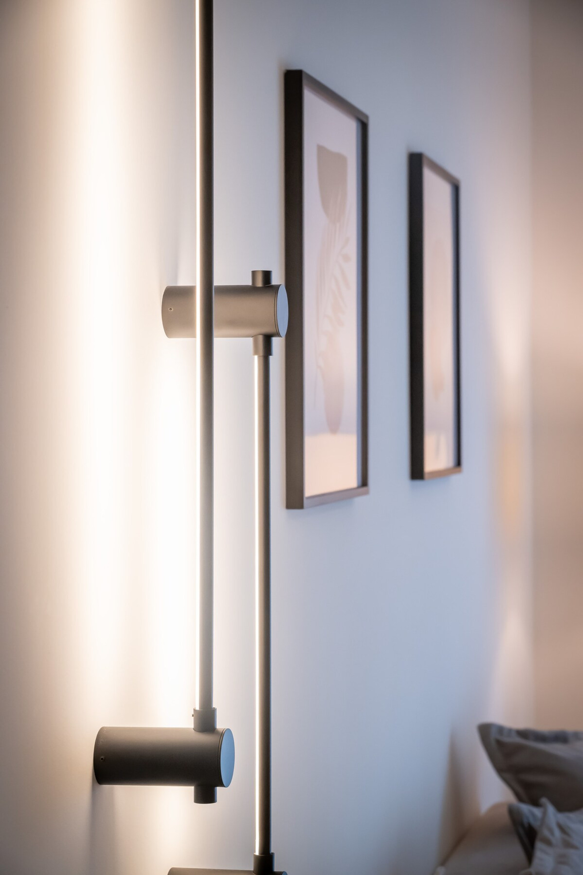 This cosy corner features a sleek, modern floor lamp casting a warm glow, complemented by tasteful wall art and a soft, inviting atmosphere—perfect for relaxing after a long day.