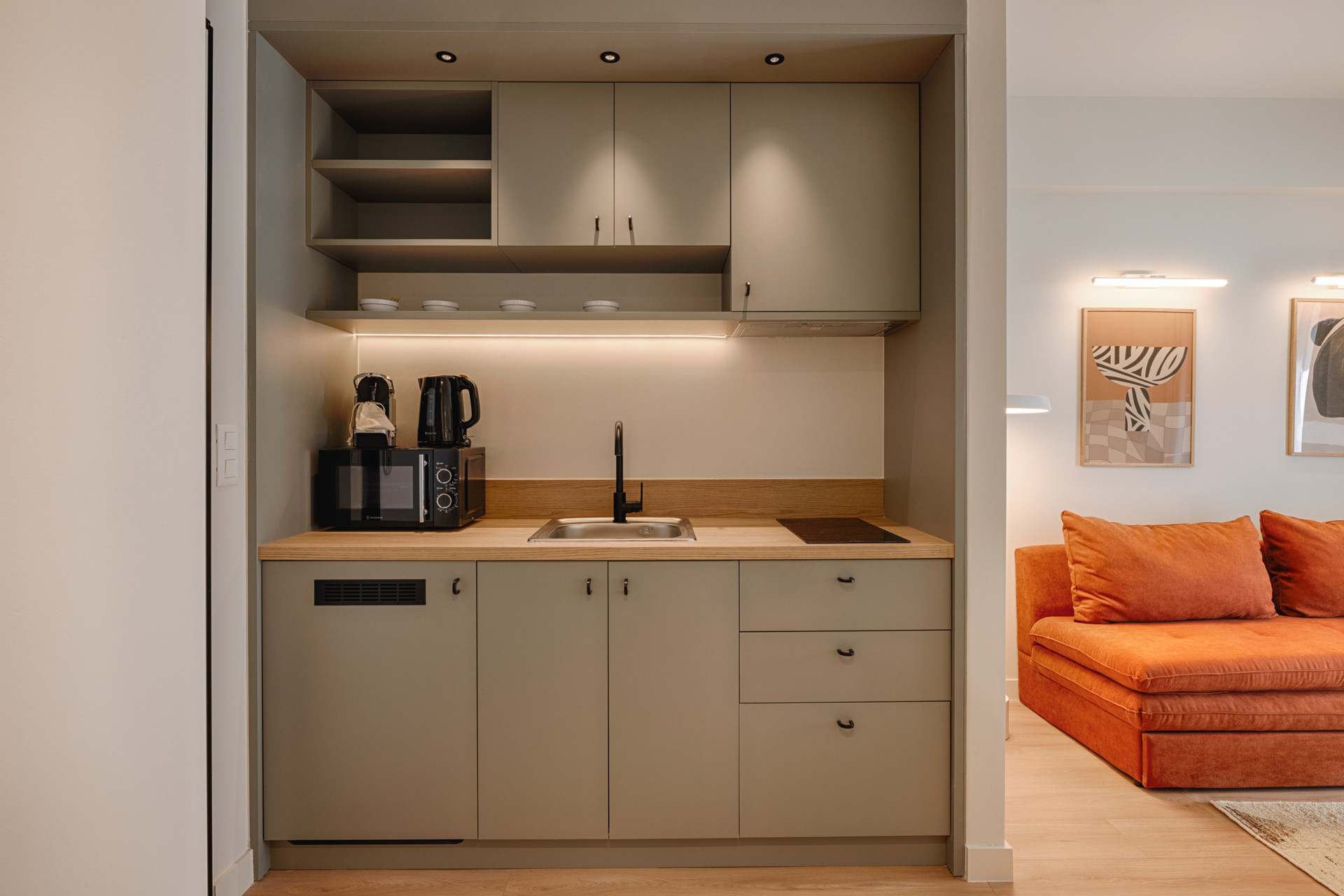 Compact kitchen with orange sofa glimpse