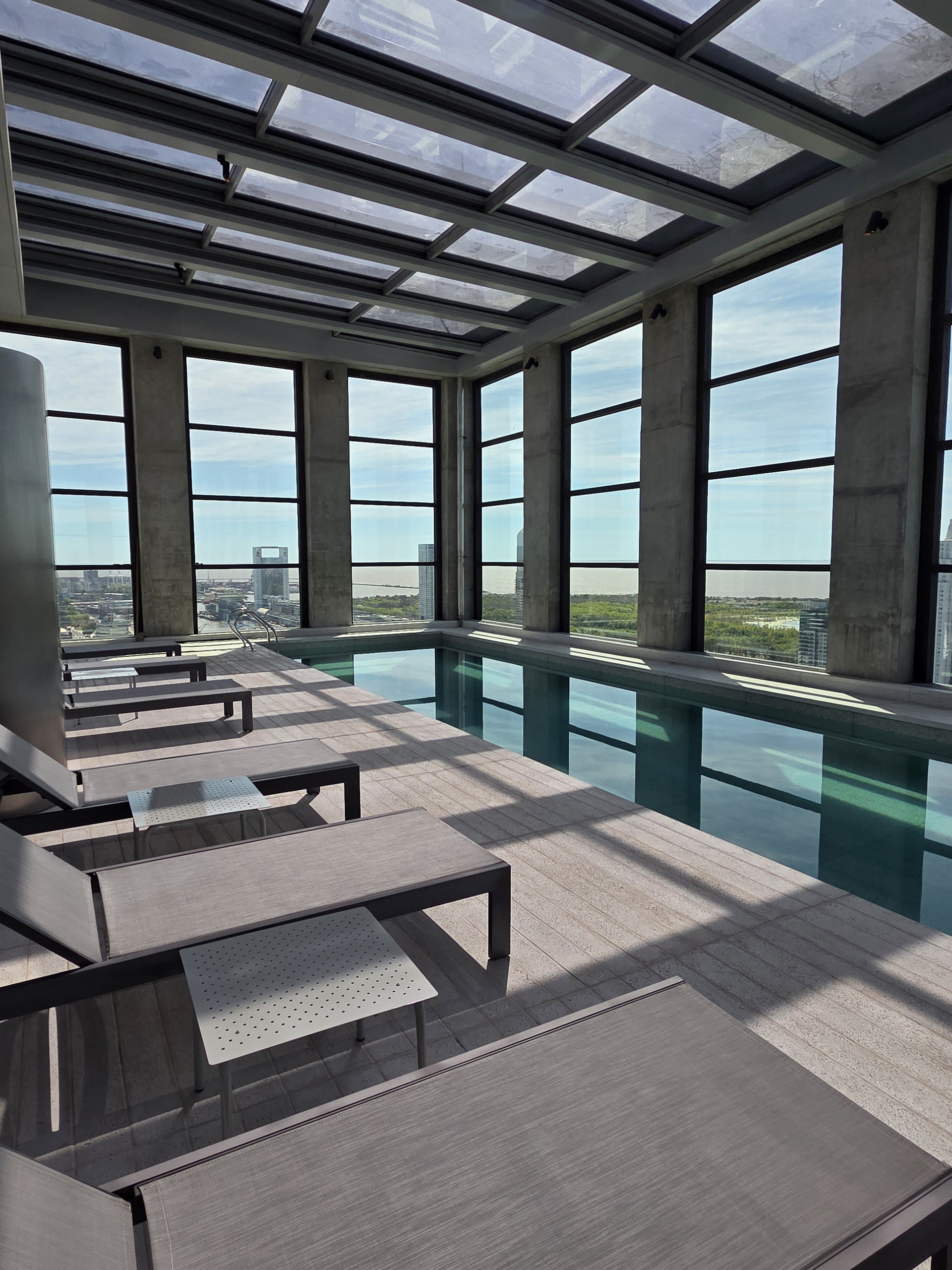 Glass-walled rooftop lounge with tables