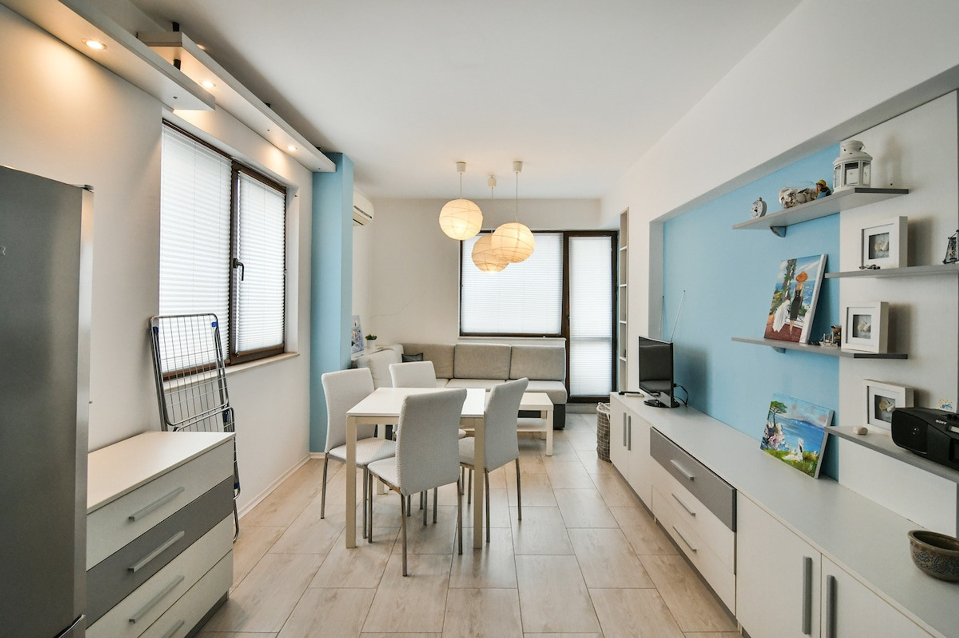 Spacious and beautifully designed living and dining area with modern lighting, a cozy sofa, and a stylish dining table. A great space to relax, work remotely, or enjoy a meal with friends and family