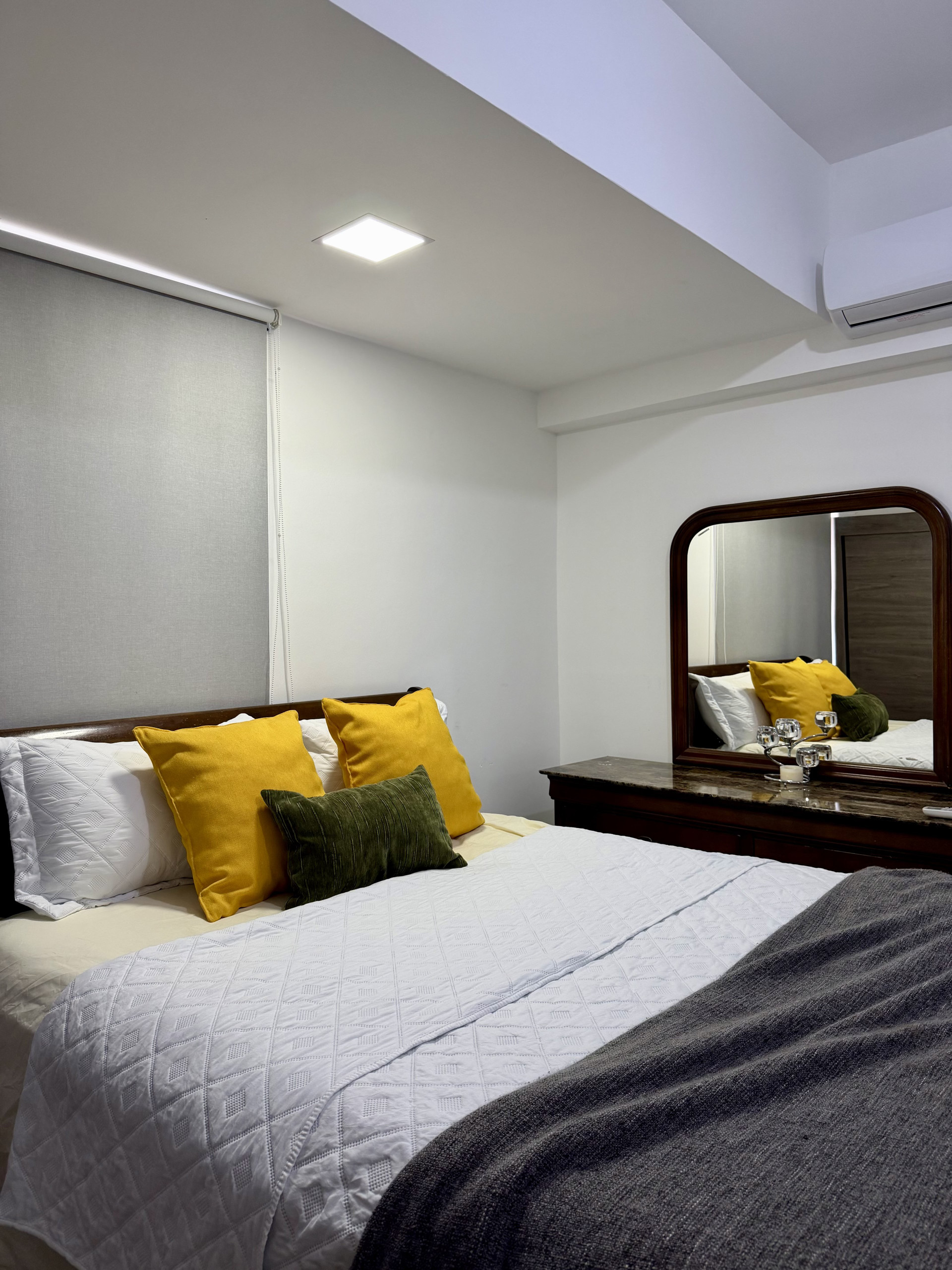 Bedroom with mirror and yellow pillows