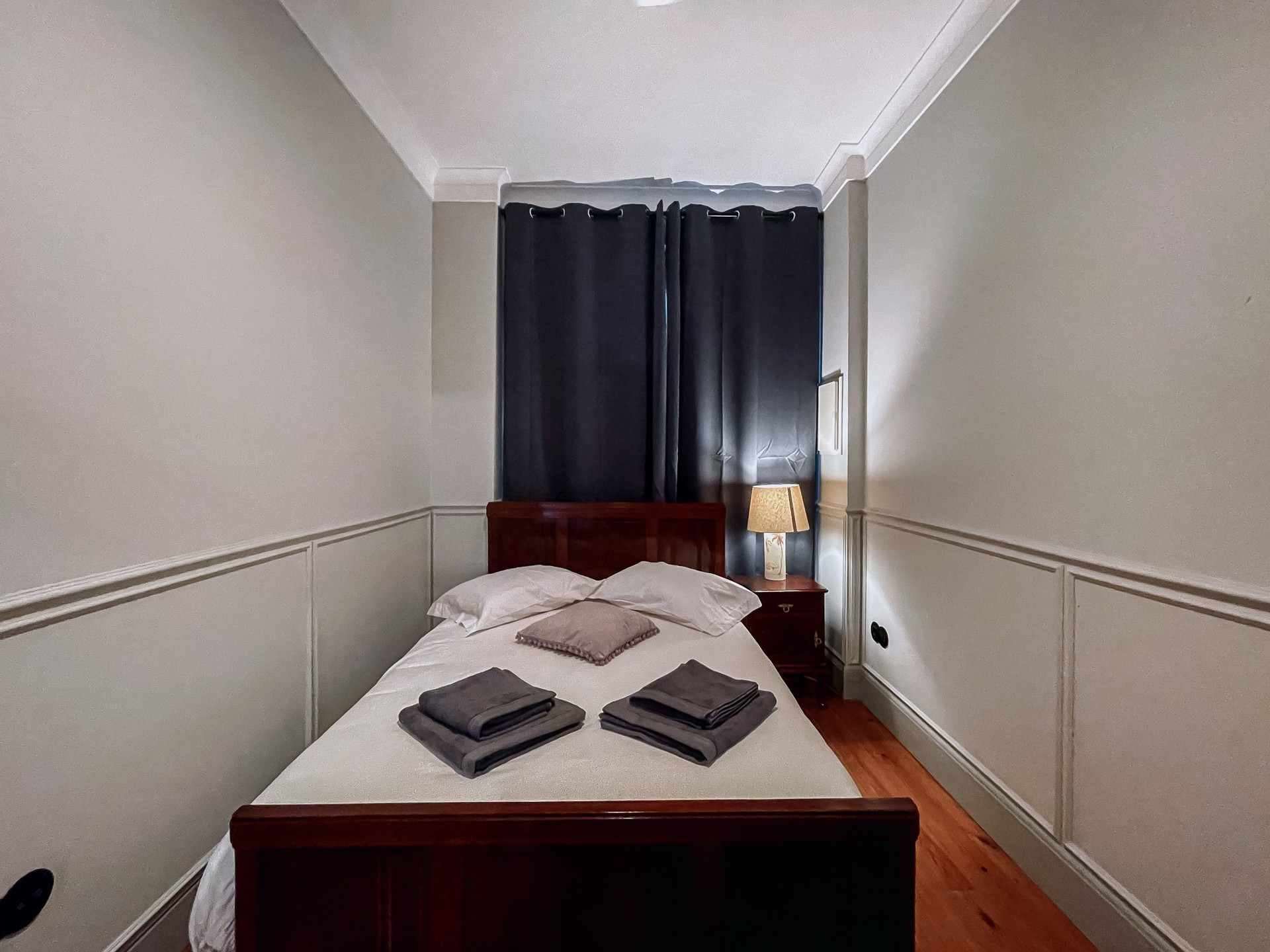Bedroom with wooden bed, dark curtains