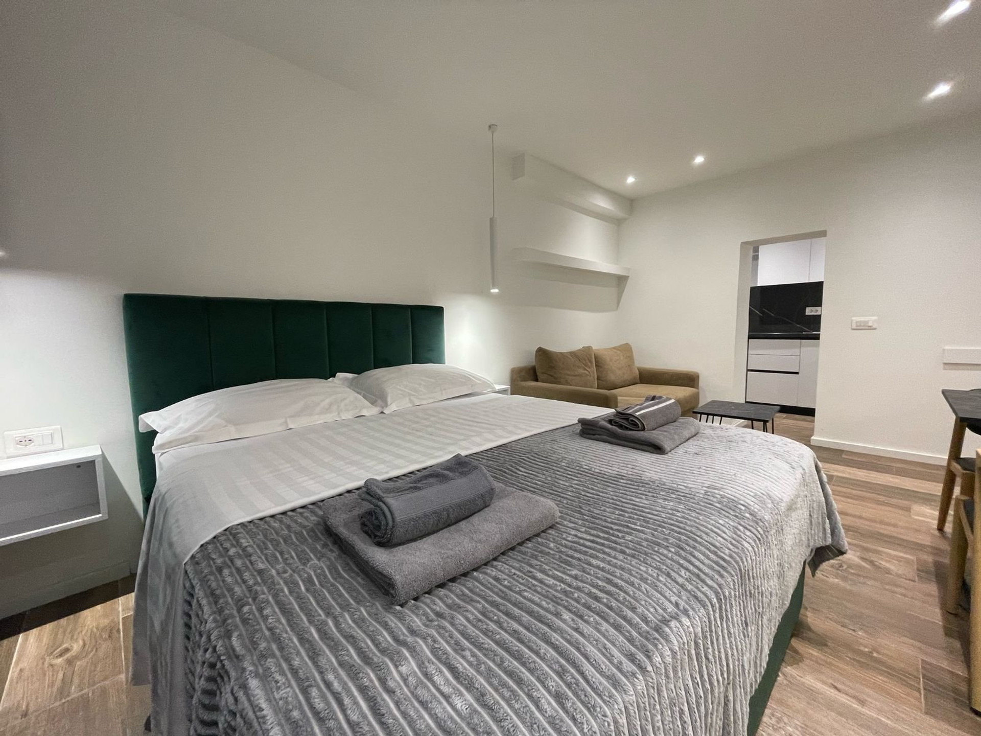 Double bed with towels, sofa behind