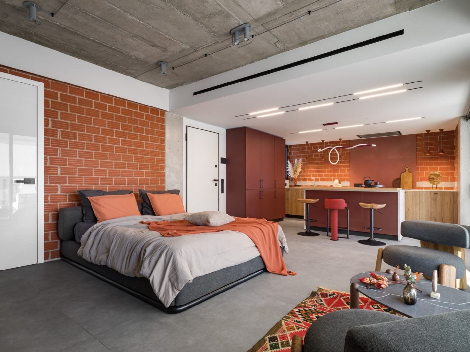 Bedroom with brick accent and kitchen