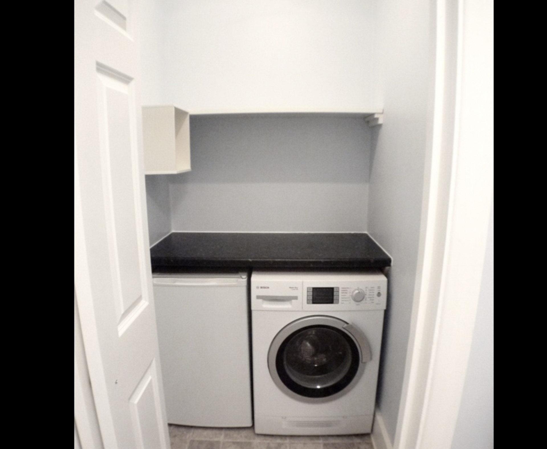 Utility closet with washer and fridge