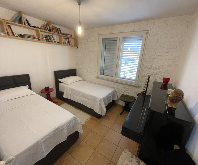 Twin bedroom with piano, window