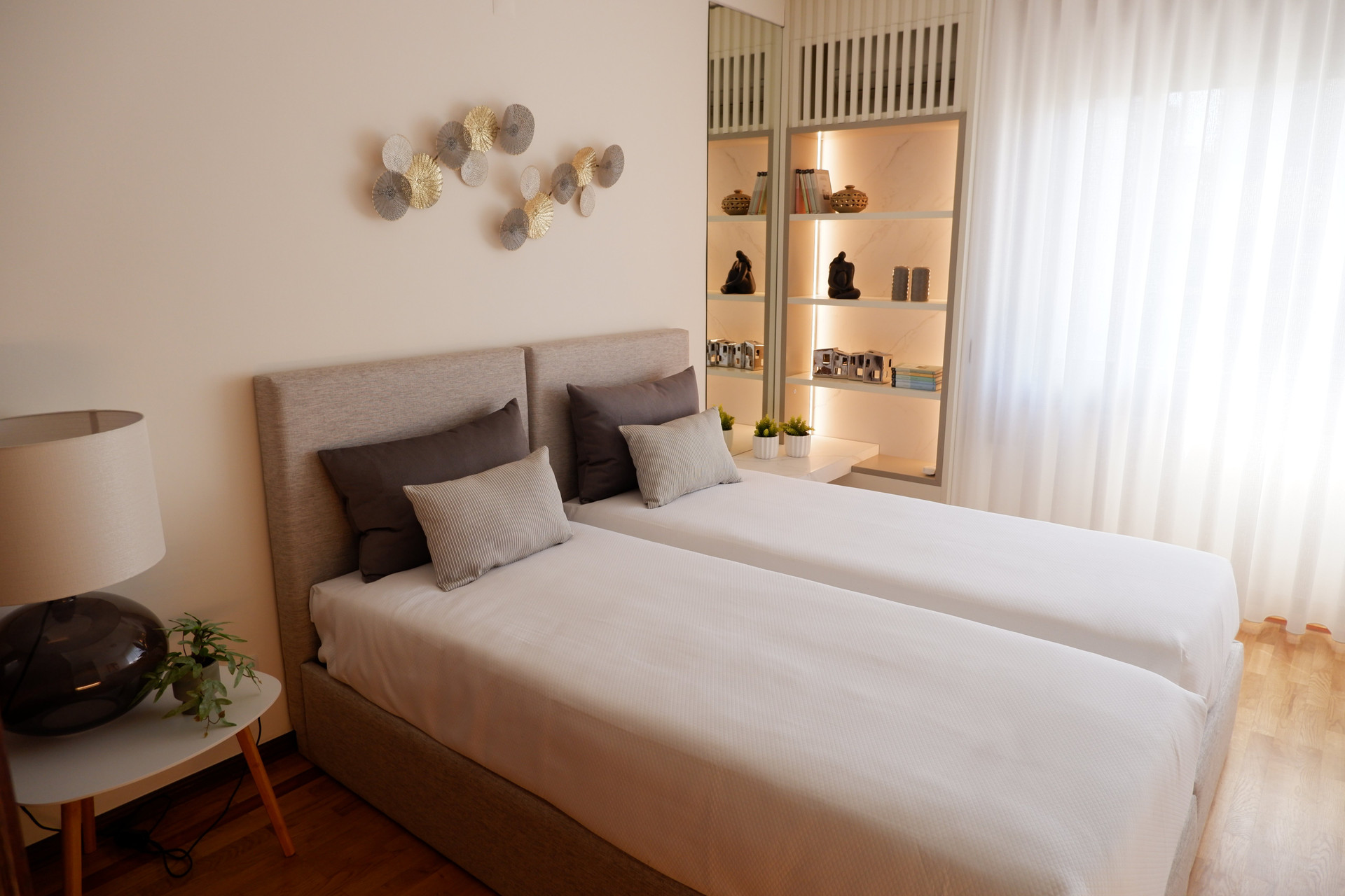 Twin bedroom with lit shelving