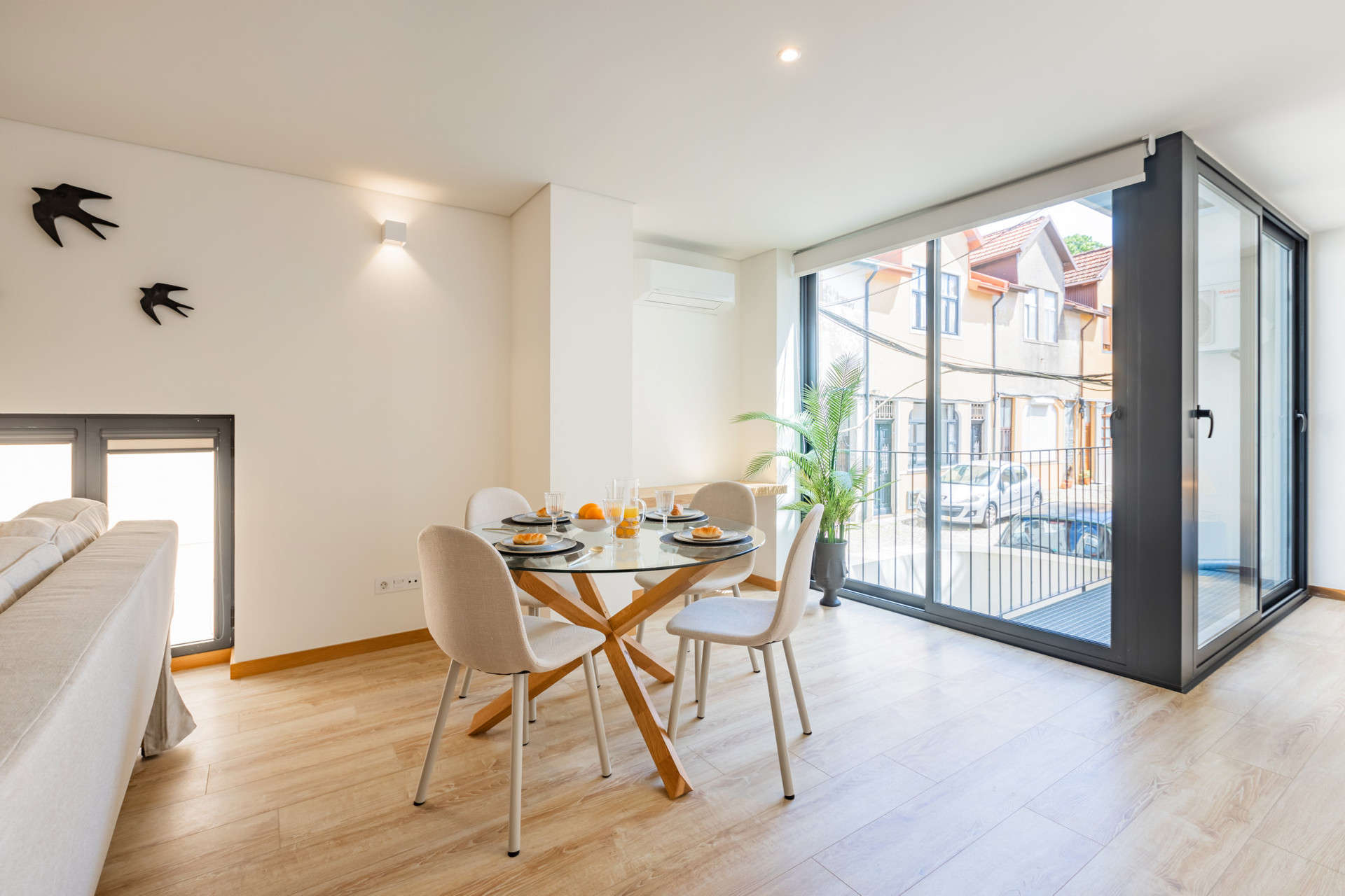 Living area with sofa, TV and AC. Dining table for 4. The full length french windows flood the space with light!