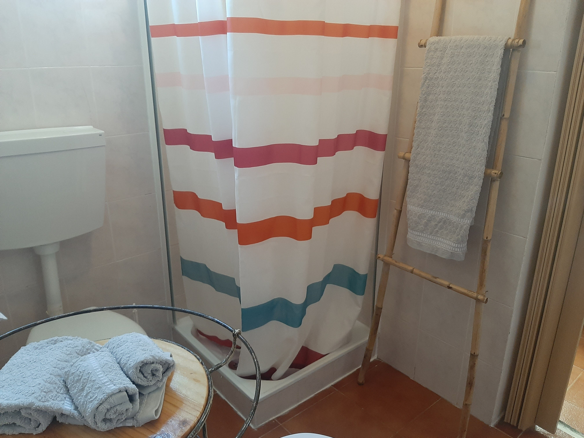 Shower with striped curtain and towels