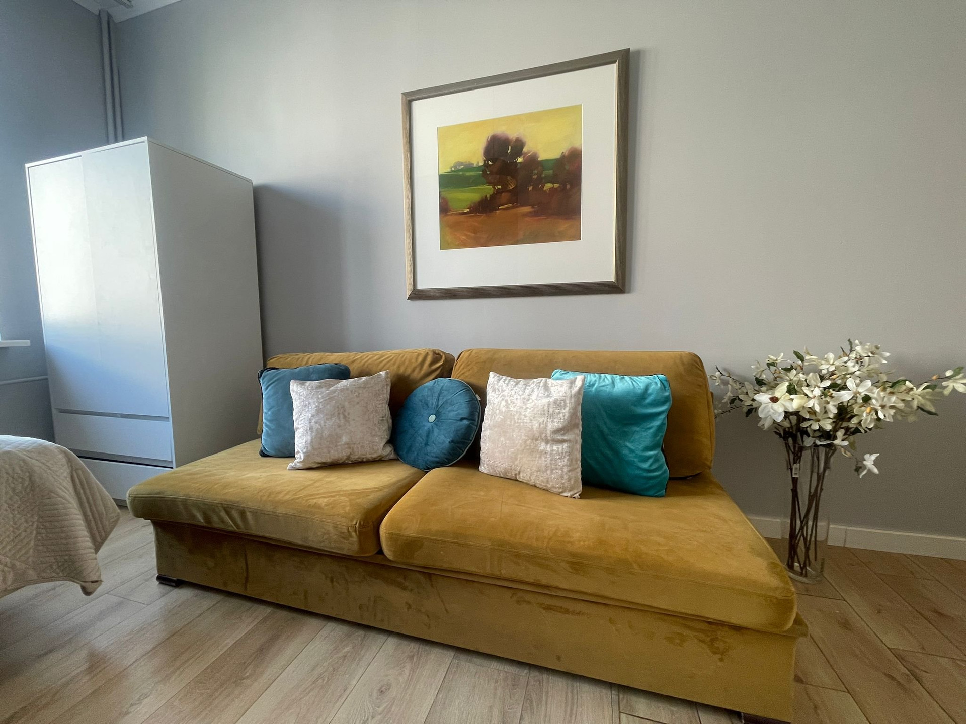 Mustard sofa with wardrobe and artwork