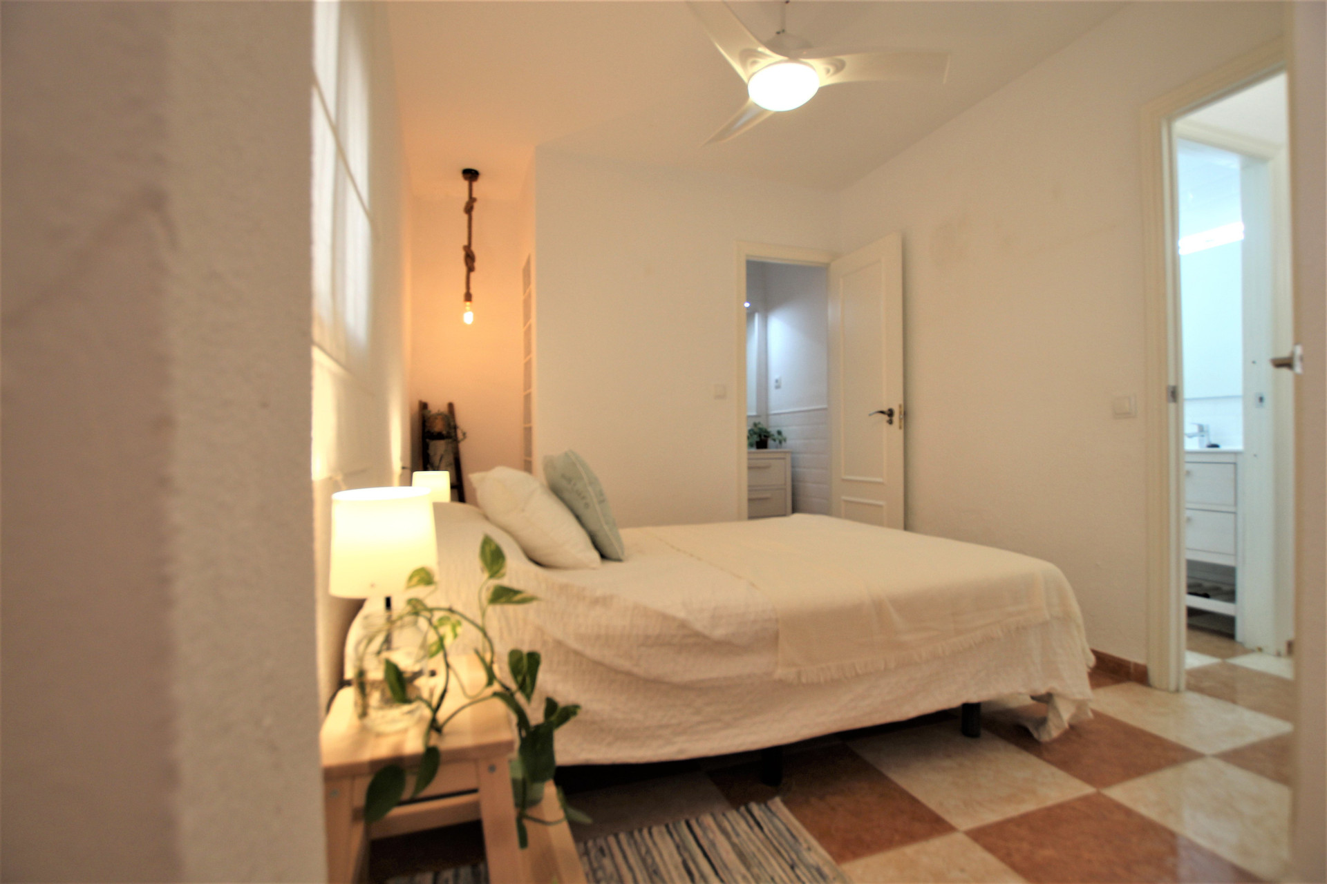 Bright master bedroom with ceiling fan