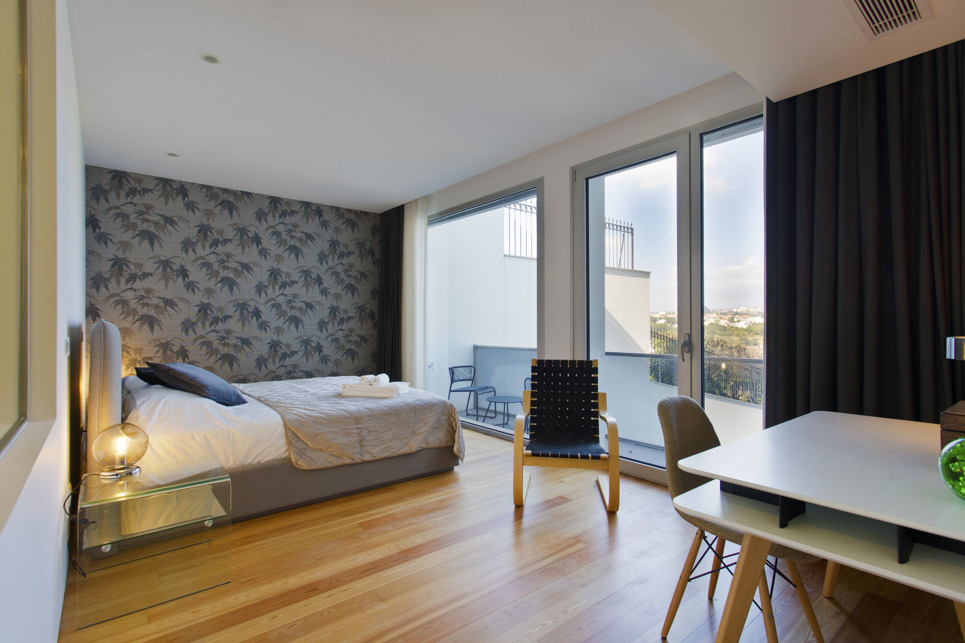 Spacious bedroom with balcony and wallpaper