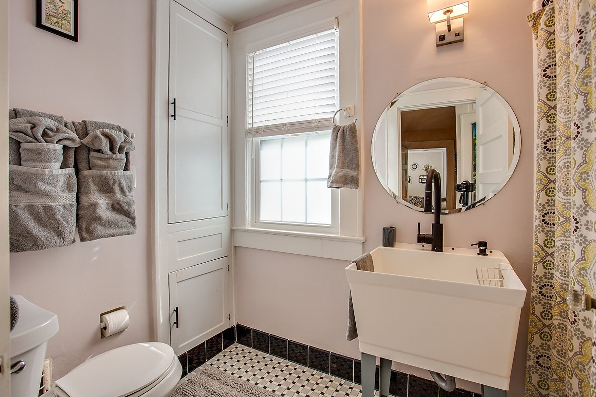 Bathroom with round mirror and tub