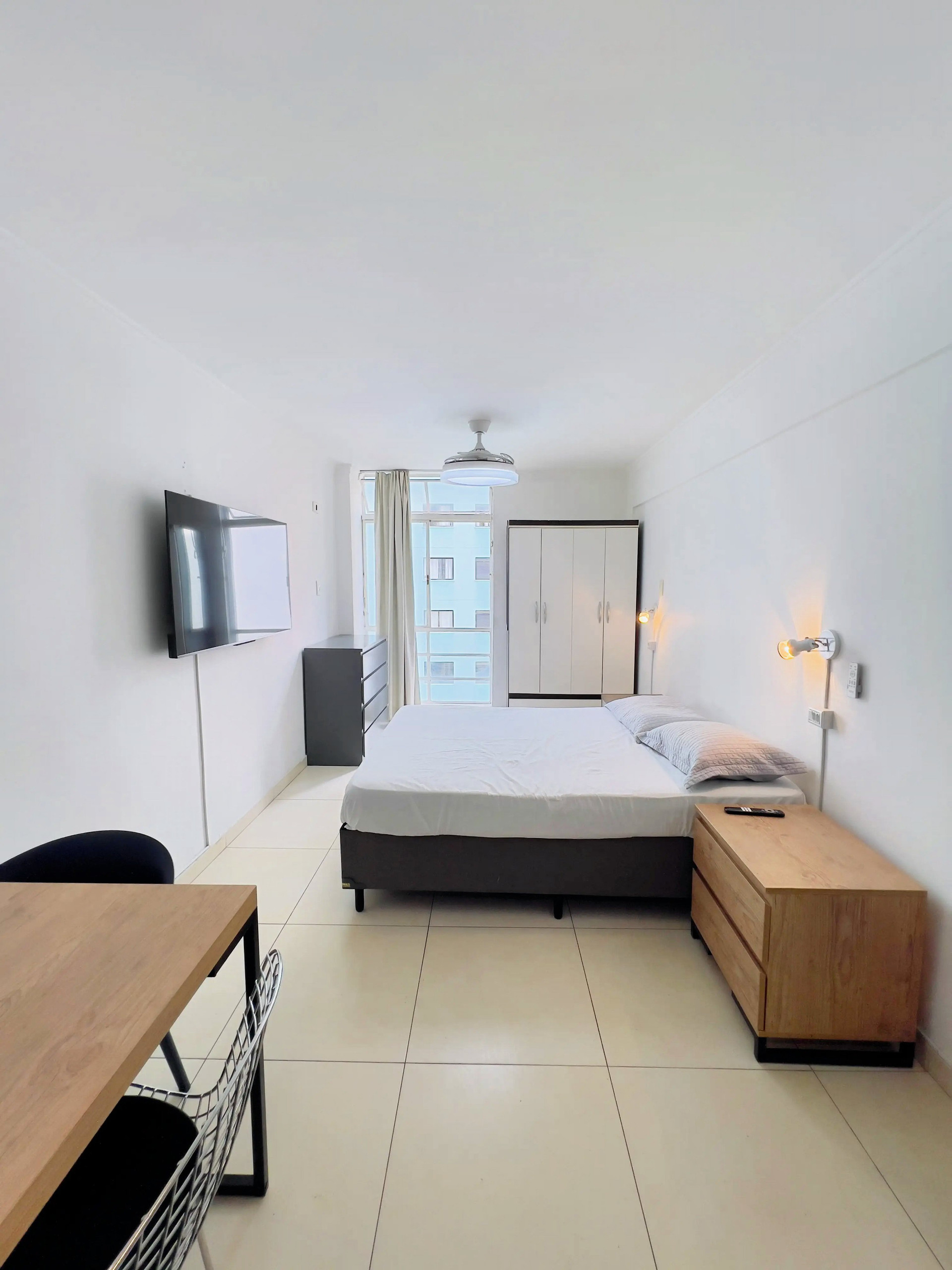 Bright studio bedroom with TV