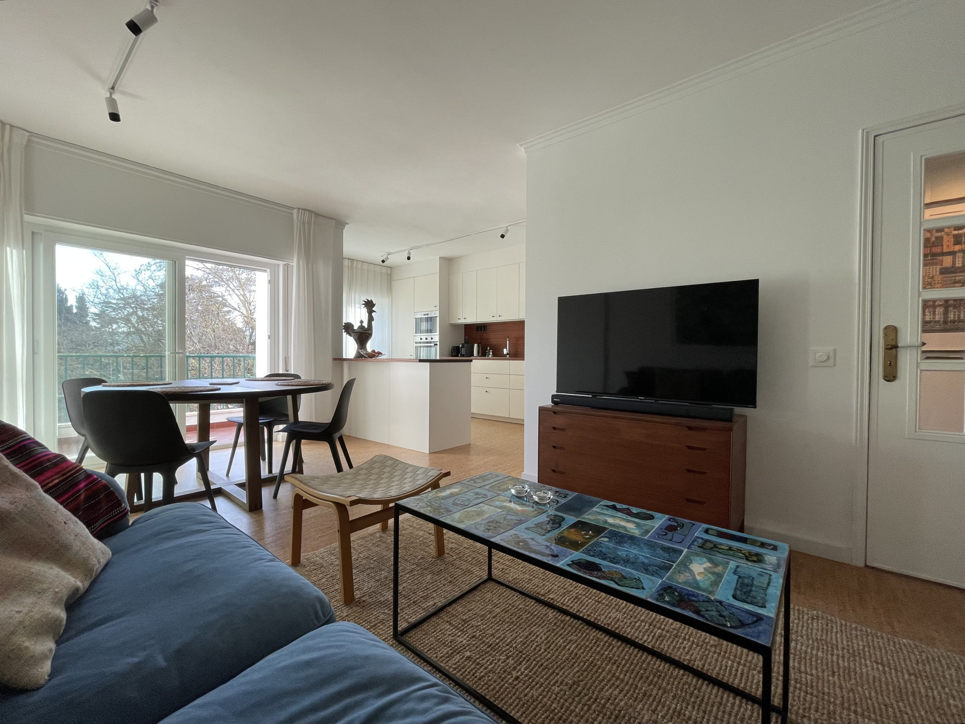 Sunny south-facing living room with mid-century Scandinavian and Portuguese furniture and unique decorative items, smart-tv and sound system.