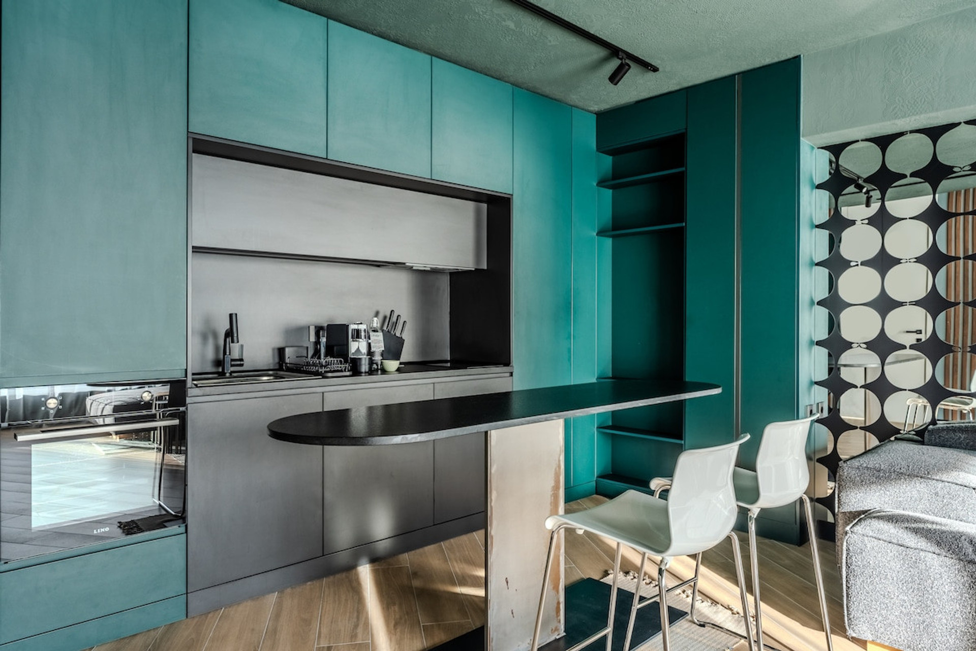 Sleek and modern kitchenette with a stylish turquoise and black design. Sleek and modern kitchen area with stylish turquoise and black design. 