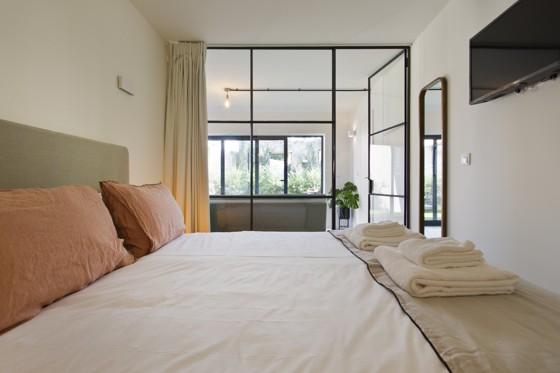 Bright bedroom glass wall garden view