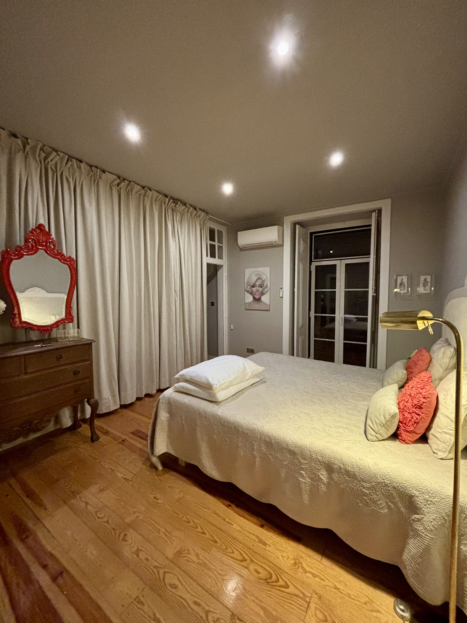 Bedroom with red mirror and balcony