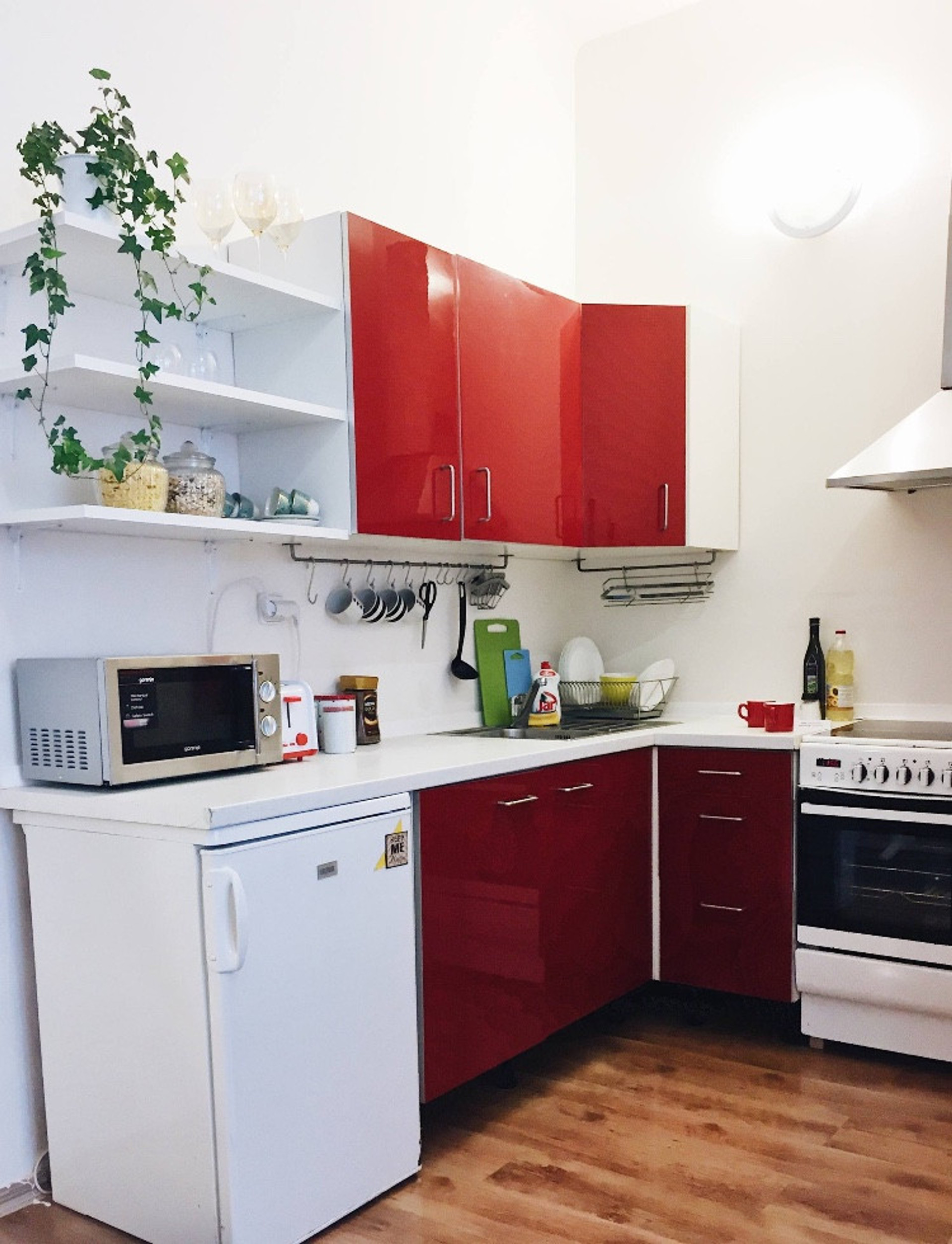 Kitchen with cooker, fridge, toaster, kettle, dishes and utensils