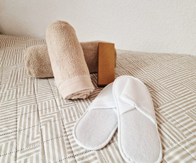 Towels and slippers on bed